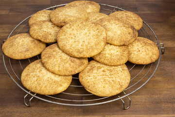 heap of snickerdoodle cookies with sugar and cinnamon on a cooling rack