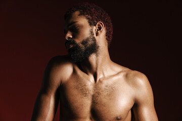 Fototapeta premium Black shirtless bearded man posing and looking aside