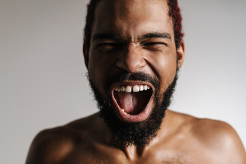Black shirtless excited man screaming and looking at camera