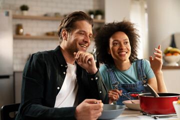 Loving couple eating lunch together at home. Husband and wife enjoying in tasty meal.