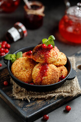 Cottage cheese pancakes. Syrniki with jam on grey background