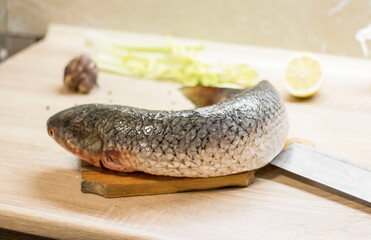 Fish. There is a raw fish cut into pieces on the kitchen board. And the whole thing.