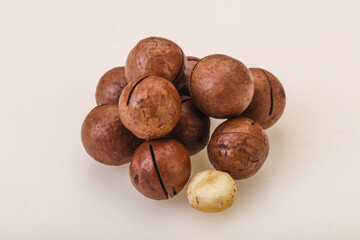 Brown macadamia nut heap over background
