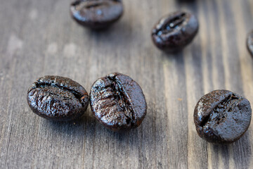 Close-up of roasted coffee beans, on dark wooden table, selective focus, horizontal