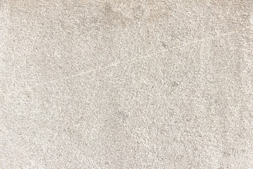 The surface of a light gray rough granite wall. Processed natural stone.