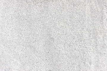 The surface of a light gray rough granite wall. Processed natural stone.