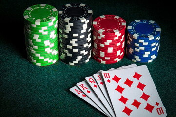 Poker cards with royal flush combination in the game. Chips on the green table in poker club