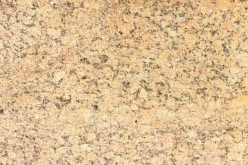 The texture of a hewn granite slab with a colorful pattern. Facing material for walls made of natural stone.