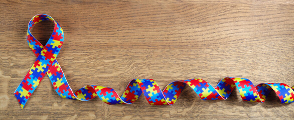 World autism awarenes day. Puzzle pattern ribbon on wooden background
