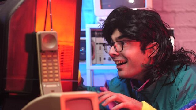 Happy retro looking man excited in front of his vintage computer screen. 80s 90s 1980 1990 era style.