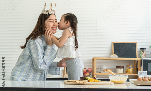 The girl hugged and kissed the single mother on Mother's Day happy in the kitchen at home.
