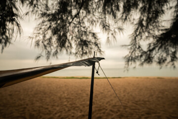 Tent poles at the beach, camping under the pine trees, sea view on vacation.