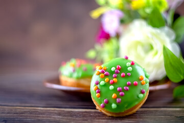 Bun, donut covered with glaze. Tutti frutti bun on a plate. Sweet pastries. Dessert. Copy space. Close-up.