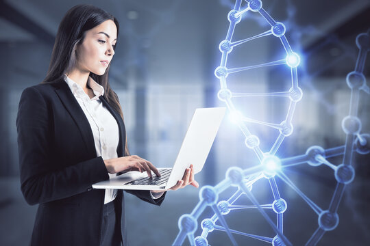 Bioengineering concept with businesswoman working on laptop and hologram DNA strand