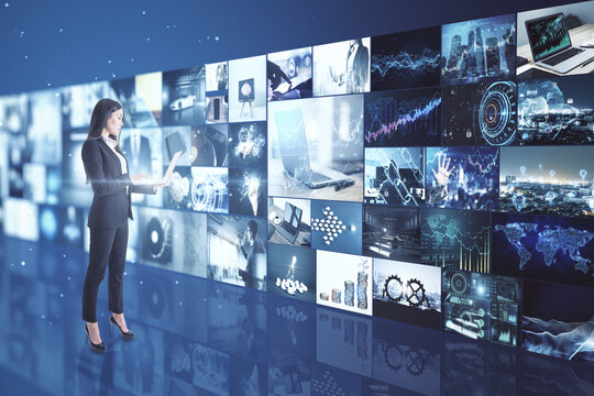 Streaming concept with businesswoman working on laptop and multimedia wall with video.