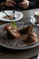 Woman eating brownie cake and whipped cream in the modern cafe. Dessert with cherries and mint.