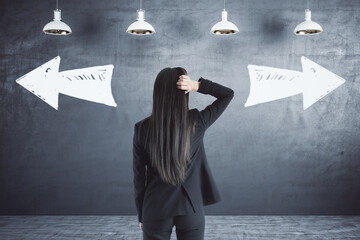 Taking decision of the future with businesswoman looking at black wall with handwritten opposite...