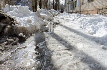 Street in the city, spring, snow melts, streams flow, sunny day.