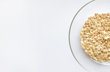 oat cereals in a glass bowl on a white background. View from above. Place for text. healthy eating concept.