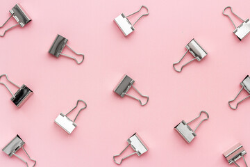 Flat lay of paper binder clips, office supplies pattern