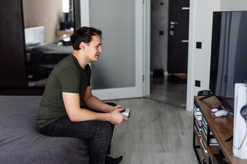 Excited young man playing video game on sofa