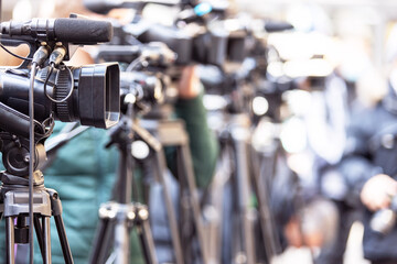 Filming media event or news conference with a television camera.