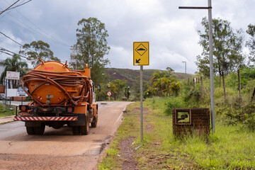Caminhão pipa passando por lombada sinalizada em pequena cidade no interior de Minas Gerais