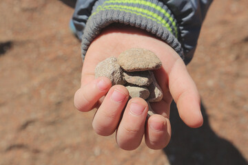 Pebbles in the child's palm.