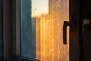 Artistic abstract photography for background. View from the window with dirty glasses to the setting sun.
