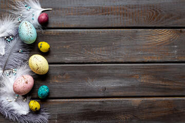 Layout of colorful Easter eggs and birds feather, top view