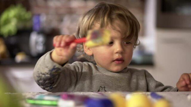 Artistic baby toddler playing with craft toys at home