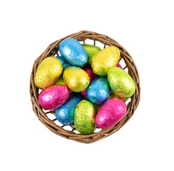 Easter eggs in basket . Chocolate eggs wrapped in colorful foil.