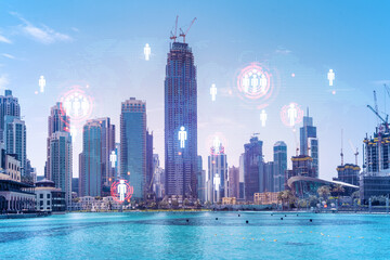 Obraz premium Skyscrapers of Dubai business downtown. International hub of trading and financial services. Social network icons hologram, concept of people connection. Double exposure. Dubai Canal waterfront.