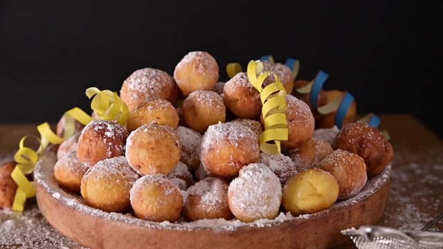Falling confetti on buns in powdered sugar. Traditional Venetian carnival and food TYPICAL. Coffee, Sfrappole or chiachiere or angel wings and aromatic coffee on a bright blue background. Copy space