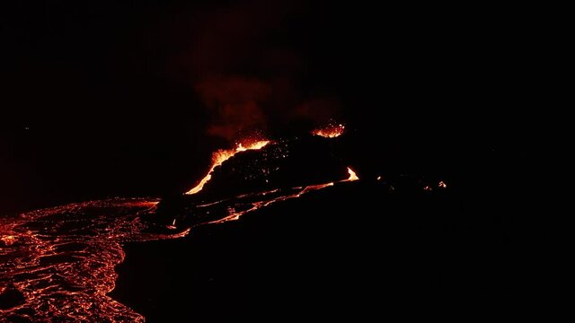 Extreme volcanic environment with burning lava field and erupting magma at night