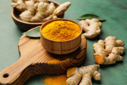 Bowl with turmeric powder on color background