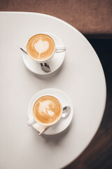 Cups of coffee with latte art on table in cafe