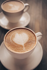 Cups of coffee with latte art on wooden background