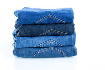 stack of blue jeans on a white background