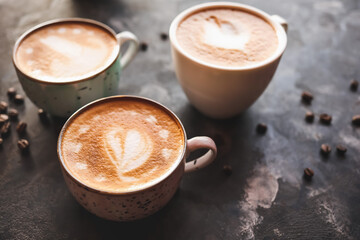 Cups of coffee with latte art on grunge background