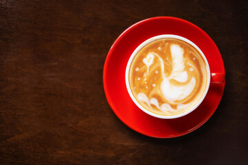 Cup of coffee with latte art on wooden background