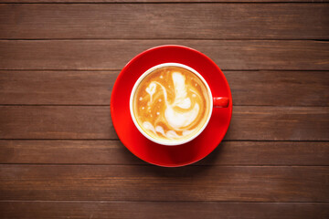 Cup of coffee with latte art on wooden background