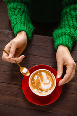 Woman with cup of latte at table in cafe
