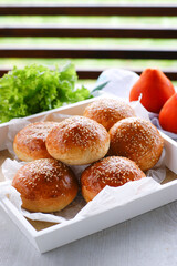 Soft puffy buns for homemade burgers made from yeast dough.