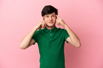 Young Russian man isolated on pink background having doubts and thinking