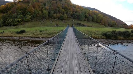 4k point of view footage walking across a wobbly wooden bridge in Glen Lyon, Scotland. This is the crossing which leads to the famous Roman Bridge.