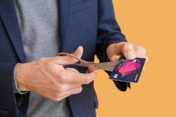 Businessman cutting credit card on color background, closeup. Bankruptcy concept