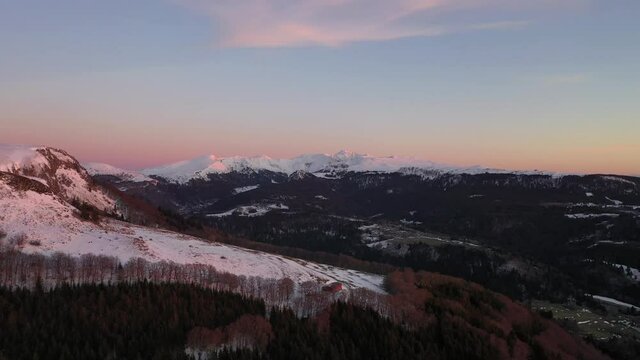 Bergerie et Coucher de soleil rose en hiver sur les monts du Sancy en Auvergne. 4K Images brutes 1/2. Paysage du Massif du Sancy dans la chaîne des Puys en France. Patrimoine mondial.