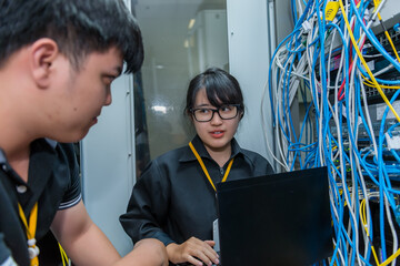 Two asian engineers working in the server room,Check the connection problems of computer networks,Thailand people