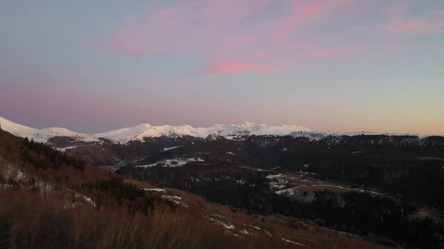 Panoramique Aérien sur le Massif du Sancy. Le Sancy en Auvergne. 4K Images brutes. Coucher de soleil Rose en hiver. Paysage du Massif du Sancy. Chaîne des Puys en France. Patrimoine mondial.
